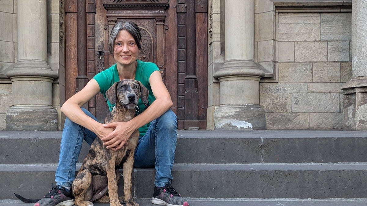 Sarah Mikulla mit ihrem Hund vor einem historischen Gebäude